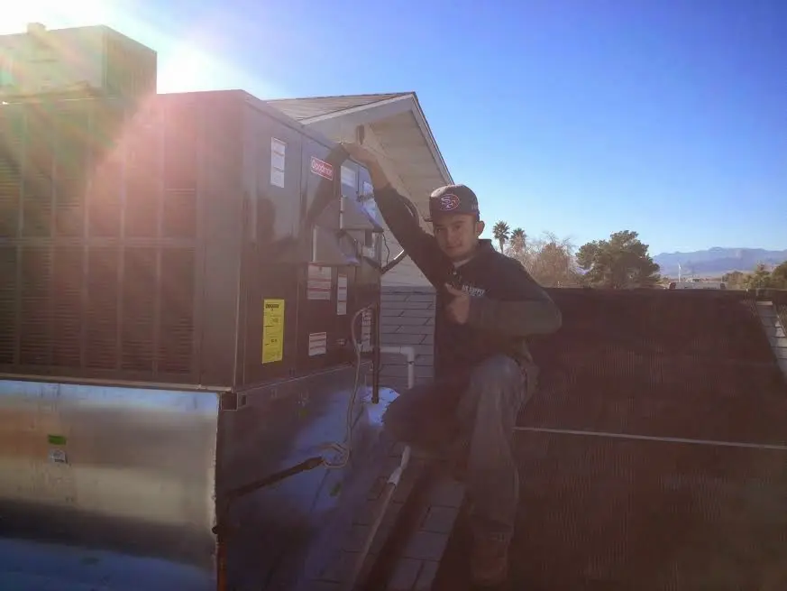 HVAC technician performing Heat Pump Repair on a rooftop unit in Plainfield